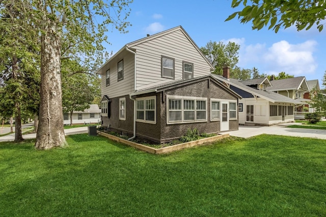693 35th St, Des Moines, IA 50312 - back of house with a yard, a chimney, and central AC