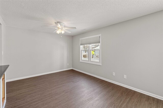 1240 49th St Unit 5, West Des Moines, IA 50266 - unfurnished room featuring dark wood-type flooring, ceiling fan, baseboards, and a textured ceiling