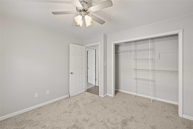 1240 49th St Unit 5, West Des Moines, IA 50266 - unfurnished bedroom with carpet flooring, baseboards, a closet, and a textured ceiling