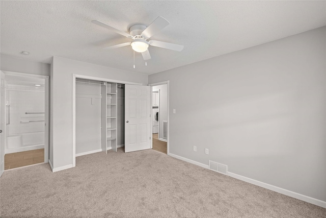 1240 49th St Unit 5, West Des Moines, IA 50266 - unfurnished bedroom featuring carpet floors, baseboards, a closet, a textured ceiling, and a ceiling fan