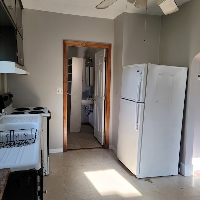 2540 Capitol Ave, Des Moines, IA 50317 - kitchen featuring white appliances, under cabinet range hood, baseboards, a ceiling fan, and light tile patterned flooring
