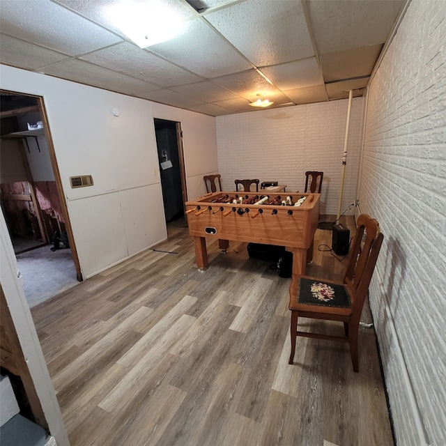 1850 King Ave, Des Moines, IA 50320 - game room with a paneled ceiling, wood finished floors, and brick wall