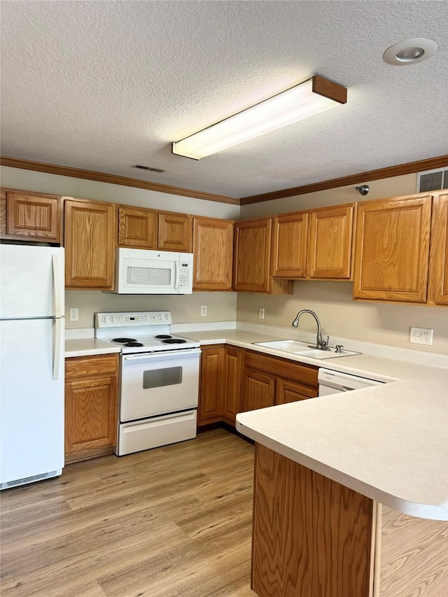 10141 Sutton Dr Unit 7, Urbandale, IA 50322 - kitchen featuring white appliances, a sink, a textured ceiling, light countertops, and light wood-type flooring