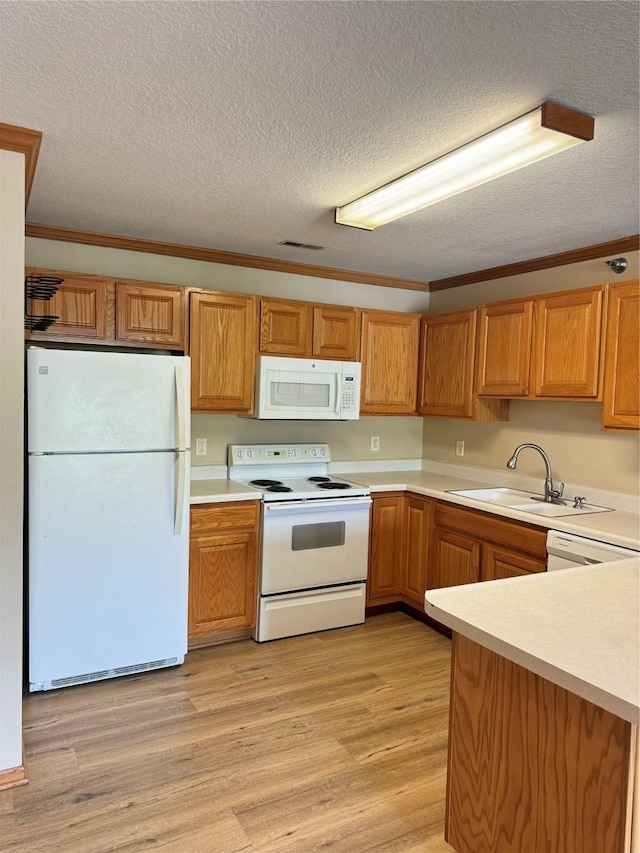 10141 Sutton Dr Unit 7, Urbandale, IA 50322 - kitchen featuring white appliances, a sink, light countertops, a textured ceiling, and light wood-style flooring