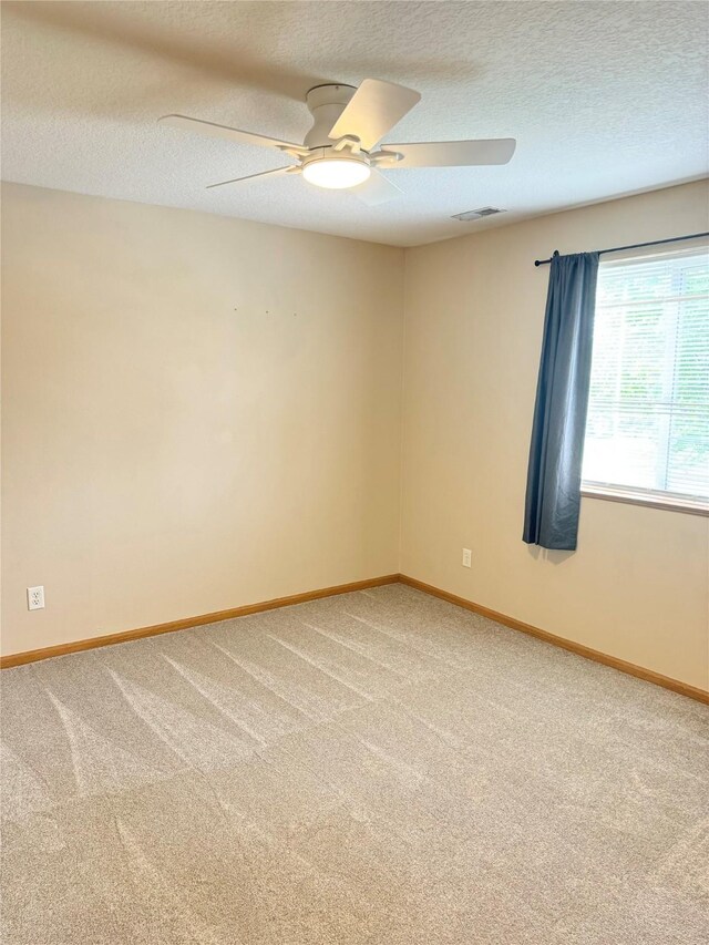 10141 Sutton Dr Unit 7, Urbandale, IA 50322 - empty room with a ceiling fan, light colored carpet, a textured ceiling, and baseboards