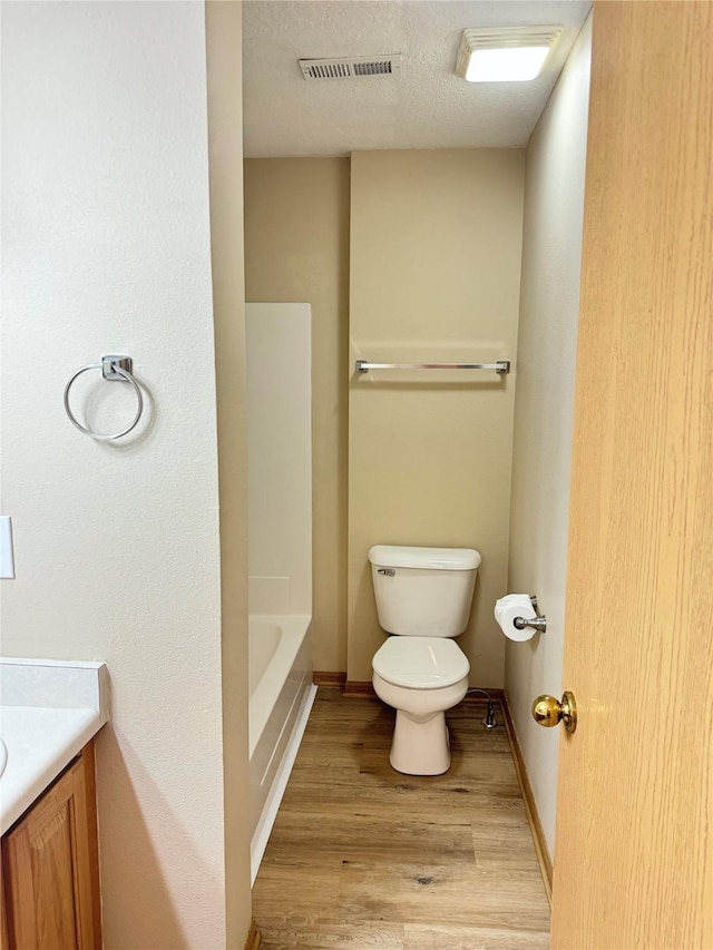 10141 Sutton Dr Unit 7, Urbandale, IA 50322 - full bath featuring toilet, wood finished floors, vanity, a tub, and baseboards