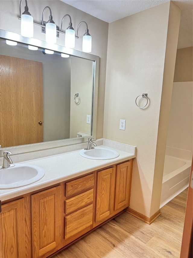 10141 Sutton Dr Unit 7, Urbandale, IA 50322 - full bath with wood finished floors, double vanity, a tub to relax in, and baseboards
