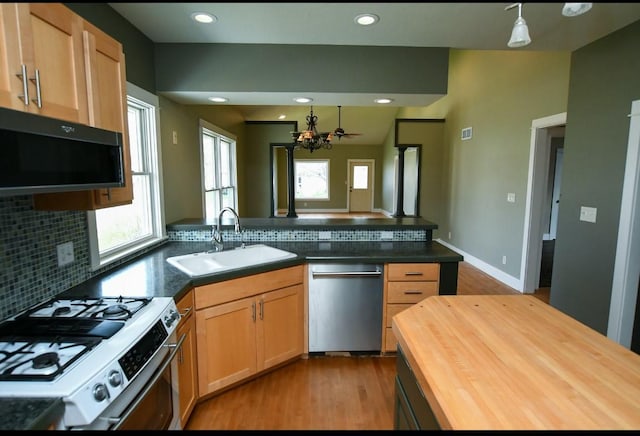 1604 Mamie Eisenhower Ave, Boone, IA 50036 - kitchen featuring stainless steel dishwasher, gas stove, a sink, wood counters, and a peninsula