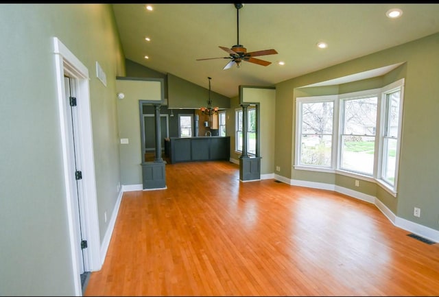 1604 Mamie Eisenhower Ave, Boone, IA 50036 - unfurnished living room with light wood-style floors, a ceiling fan, a chandelier, lofted ceiling, and baseboards