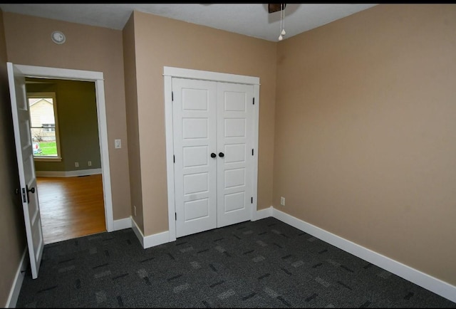 1604 Mamie Eisenhower Ave, Boone, IA 50036 - unfurnished bedroom with a closet, dark carpet, and baseboards