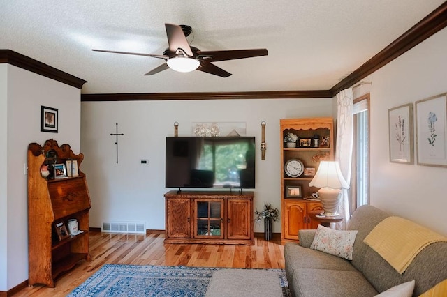 living area with crown molding, light wood finished floors, a ceiling fan, and baseboards