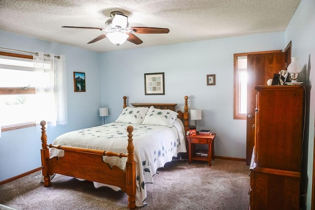 bedroom featuring multiple windows, carpet, baseboards, a ceiling fan, and a textured ceiling