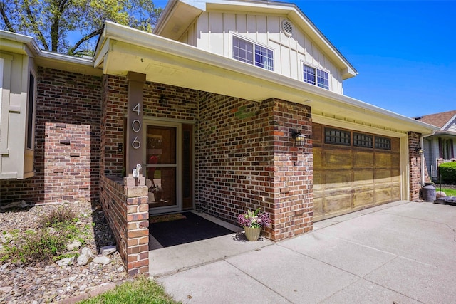 406 NW Kimberly Ln, Ankeny, IA 50023 - view of exterior entry featuring board and batten siding, brick siding, concrete driveway, and an attached garage