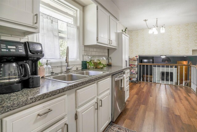 406 NW Kimberly Ln, Ankeny, IA 50023 - kitchen featuring wallpapered walls, dishwasher, a sink, white cabinets, and dark wood-style flooring