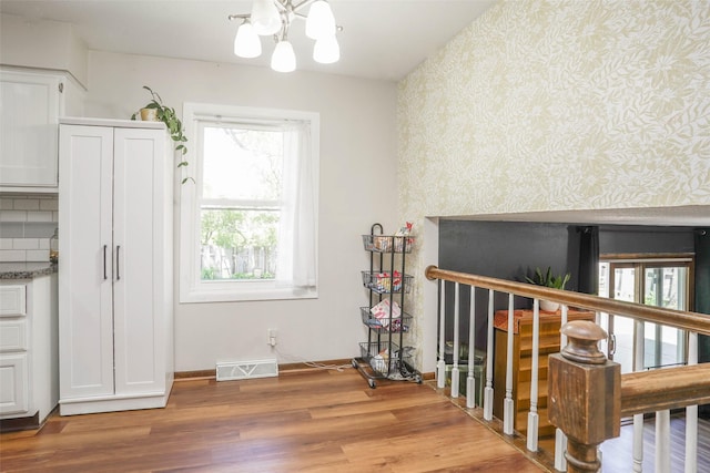 406 NW Kimberly Ln, Ankeny, IA 50023 - dining area featuring wallpapered walls, a chandelier, wood finished floors, and baseboards