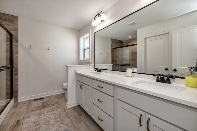980 Daybreak Dr, Waukee, IA 50263 - bathroom with a shower stall, double vanity, toilet, and baseboards