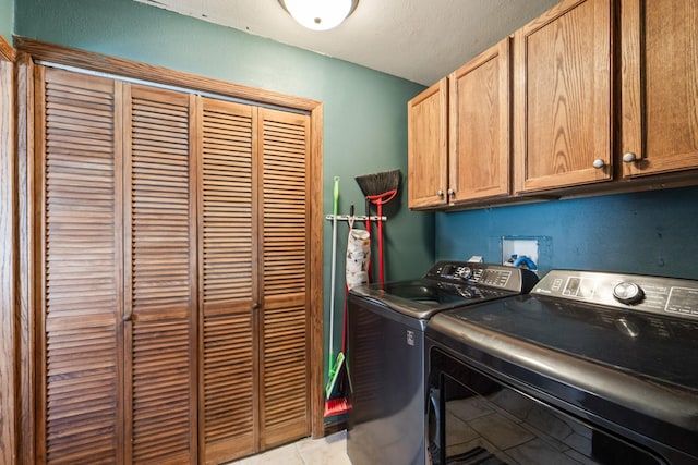225 NW 50th Pl, Des Moines, IA 50313 - laundry room with washing machine and clothes dryer, cabinet space, and light tile patterned flooring