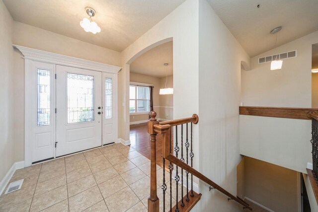 1420 Hannah Ln, Waukee, IA 50263 - entrance foyer with baseboards, arched walkways, light tile patterned floors, and vaulted ceiling