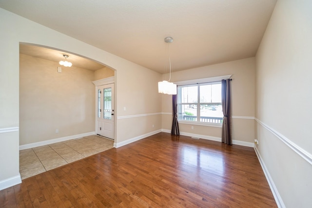 1420 Hannah Ln, Waukee, IA 50263 - spare room with wood finished floors, arched walkways, healthy amount of natural light, and baseboards