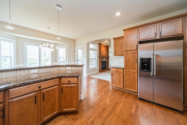 1420 Hannah Ln, Waukee, IA 50263 - kitchen with stainless steel fridge, brown cabinets, light wood-style flooring, and recessed lighting