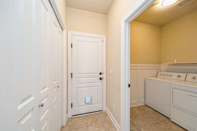 1420 Hannah Ln, Waukee, IA 50263 - laundry area with washing machine and clothes dryer, light tile patterned flooring, and wainscoting
