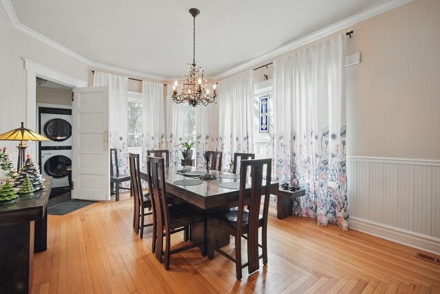 207 Kellogg Ave, Dallas Center, IA 50063 - dining space with stacked washer / dryer, a chandelier, ornamental molding, and wainscoting