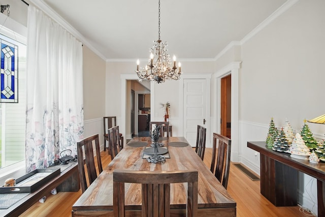 207 Kellogg Ave, Dallas Center, IA 50063 - dining room featuring a chandelier, light wood-style flooring, crown molding, and healthy amount of natural light