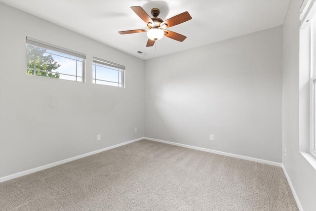 unfurnished room with carpet floors, a ceiling fan, and baseboards