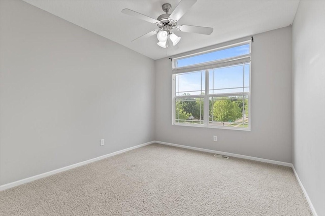 carpeted empty room featuring baseboards and ceiling fan
