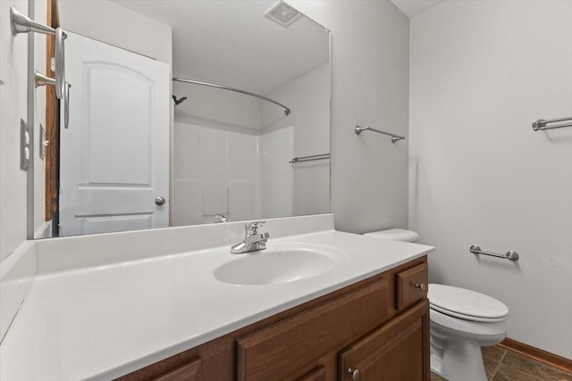 bathroom with toilet, vanity, and a shower