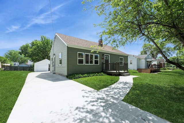 2311 50th St, Des Moines, IA 50310 - view of front facade with a wooden deck, a front lawn, a detached garage, and an outdoor structure
