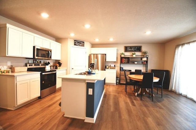 2010 N 7th St, Indianola, IA 50125 - kitchen with appliances with stainless steel finishes, a sink, dark wood finished floors, white cabinetry, and recessed lighting
