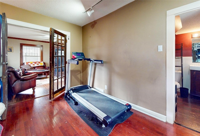 1415 46th St, Des Moines, IA 50311 - workout room with french doors, wood-type flooring, baseboards, a textured ceiling, and rail lighting