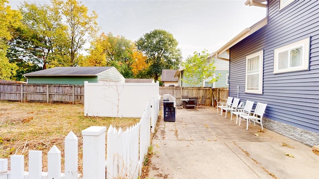 1415 46th St, Des Moines, IA 50311 - fenced backyard with a patio area, an outbuilding, and a storage shed