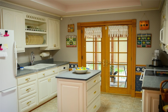 320 E 3rd St S, Newton, IA 50208 - kitchen featuring freestanding refrigerator, a sink, french doors, wallpapered walls, and dark countertops