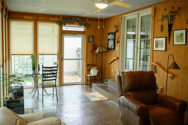 320 E 3rd St S, Newton, IA 50208 - living room featuring a ceiling fan and wood walls