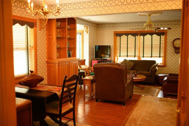 320 E 3rd St S, Newton, IA 50208 - living area featuring wallpapered walls, a chandelier, and wood finished floors