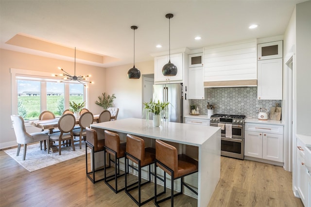 2770 NW 167th St, Clive, IA 50325 - kitchen with stainless steel appliances, a center island, premium range hood, light wood-style flooring, and decorative backsplash