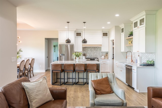2770 NW 167th St, Clive, IA 50325 - kitchen with stainless steel appliances, a sink, light countertops, open floor plan, and backsplash