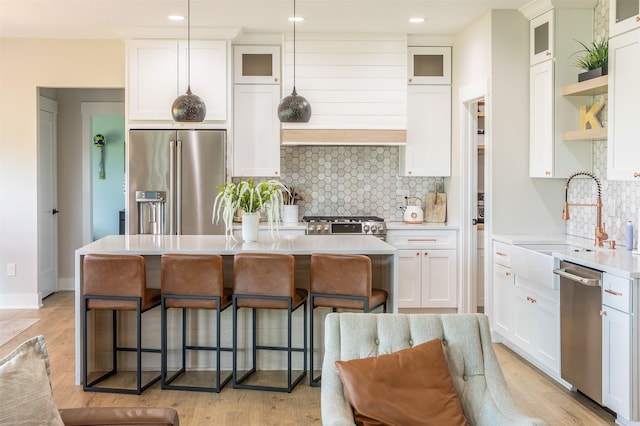 2770 NW 167th St, Clive, IA 50325 - kitchen with stainless steel appliances, a breakfast bar, a kitchen island, a sink, and backsplash