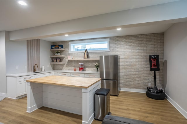 2770 NW 167th St, Clive, IA 50325 - kitchen featuring freestanding refrigerator, wooden counters, a sink, baseboards, and light wood-style flooring