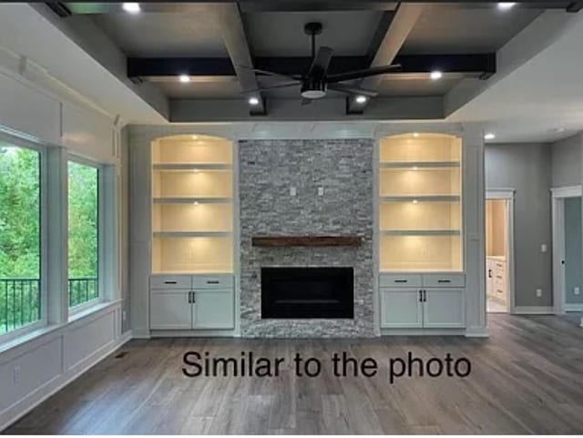 18099 Townsend Dr, Clive, IA 50325 - unfurnished living room with wood finished floors, built in features, beam ceiling, a stone fireplace, and coffered ceiling