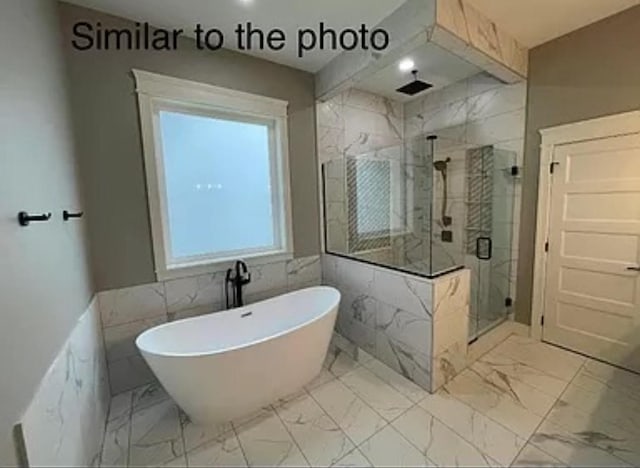 18099 Townsend Dr, Clive, IA 50325 - full bathroom featuring a freestanding tub, a marble finish shower, marble look tile flooring, and tile walls