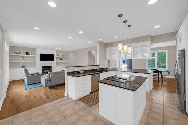 947 11th Ave SE, Altoona, IA 50009 - kitchen with a peninsula, stainless steel appliances, a sink, a large fireplace, and recessed lighting