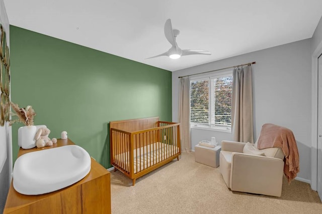 947 11th Ave SE, Altoona, IA 50009 - bedroom with a nursery area, a ceiling fan, carpet, and baseboards
