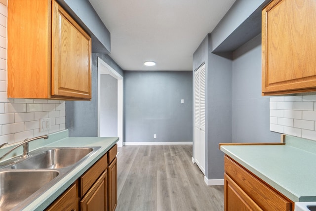 208 Van Buren Dr, Van Meter, IA 50261 - kitchen featuring a sink, light wood-style floors, backsplash, baseboards, and recessed lighting