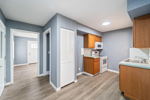 208 Van Buren Dr, Van Meter, IA 50261 - kitchen featuring white appliances, a sink, light wood-style flooring, and tasteful backsplash