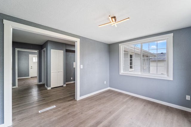 208 Van Buren Dr, Van Meter, IA 50261 - empty room featuring wood finished floors and baseboards