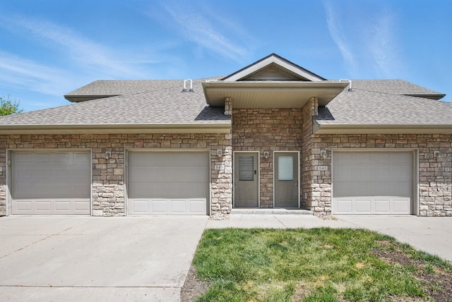 545 Maggie Ln, Altoona, IA 50009 - view of front facade featuring a shingled roof, concrete driveway, stone siding, and an attached garage