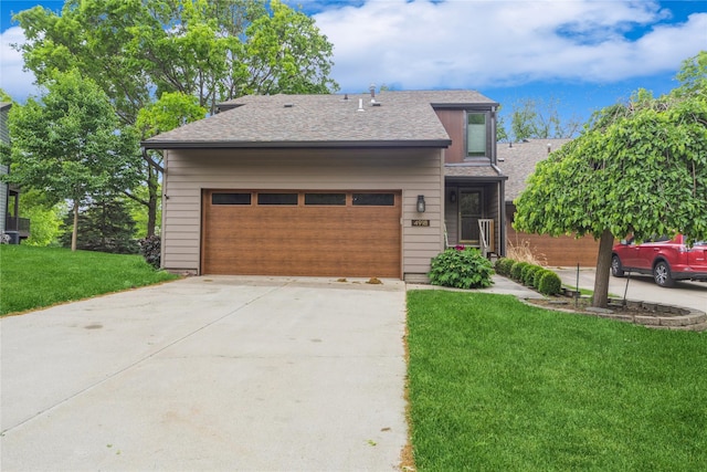 view of front facade with a front lawn, a garage, driveway, and roof with shingles